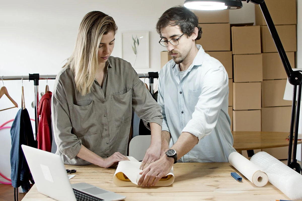 Two people wrapping merchandise at a small-business worktable