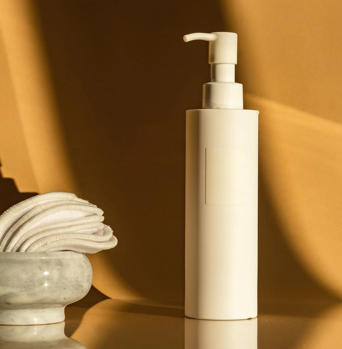 An unbranded personal care pump bottle with cotton pads